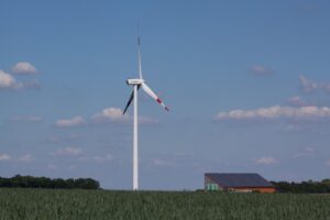 solar panels and wind turbines in a green landscape at sunshine